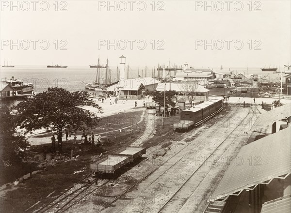 Port of Spain wharf. Empty freight cars and passenger carriages sit on sidings at Port of Spain wharf, where several large sailing ships are anchored at the docks. Port of Spain, Trinidad, circa 1912. Port of Spain, Trinidad and Tobago, Trinidad and Tobago, Caribbean, North America .