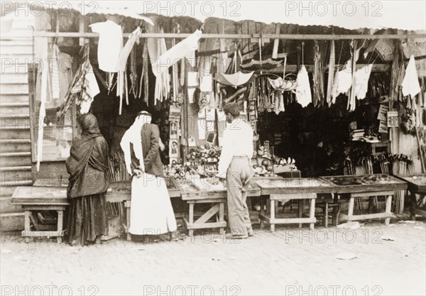 Stall at a 'shuk', Palestine. Shoppers browse a variety of items for sale on a stall at a 'shuk' (open air market). British Mandate of Palestine (Middle East), circa 1938., Middle East, Asia.