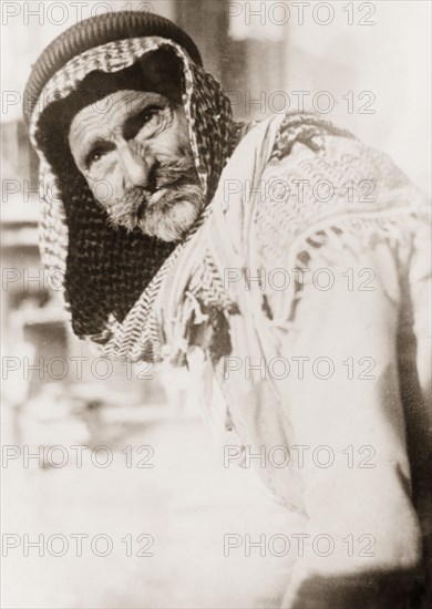Portrait of an Arab man, Palestine. Portrait of an elderly Arab man, taken on a street in Palestine. He wears a traditional 'keffiyeh' (headdress), kept in place with an 'agal' (cord tie). British Mandate of Palestine (Middle East), circa 1938., Middle East, Asia.