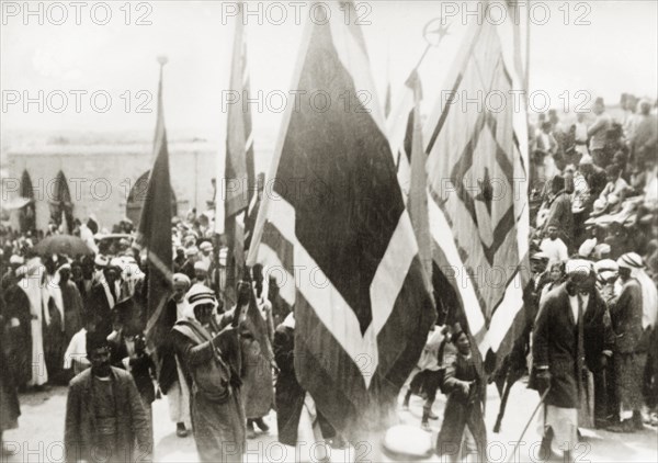 Flag bearers at a Nebi Musa procession. Muslim pilgrims bearing flags take part in a Nebi Musa procession: an annual pilgrimage made by Palestinian Muslims to Nebi Musa near Jericho, the supposed burial place of Moses. Ramallah, British Mandate of Palestine (West Bank, Middle East), circa 1938. Ramallah, West Bank, West Bank (Palestine), Middle East, Asia.