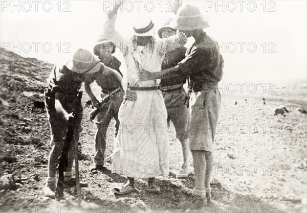British soldiers searching a Palestinian Arab. Four British soldiers perform a body search on a Palestinian Arab detainee. During the period of the Great Uprising (1936-39), an additional 20,000 British troops were deployed to Palestine in an attempt to clamp down on Arab dissidence. British Mandate of Palestine (Middle East), circa 1938., Middle East, Asia.