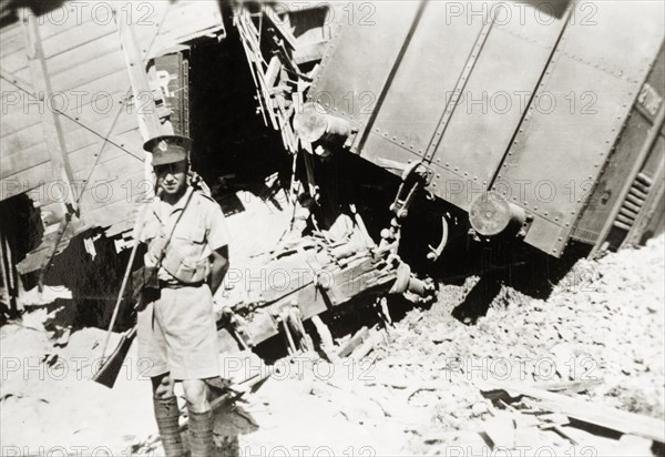 Guarding a derailment on the Kantara line. A British soldier guards the wreckage of a train on the Kantara line, derailed in a sabotage attack by Palestinian Arab dissidents during the Great Uprising (1936-39). British Mandate of Palestine (Middle East), circa 1938., Middle East, Asia.