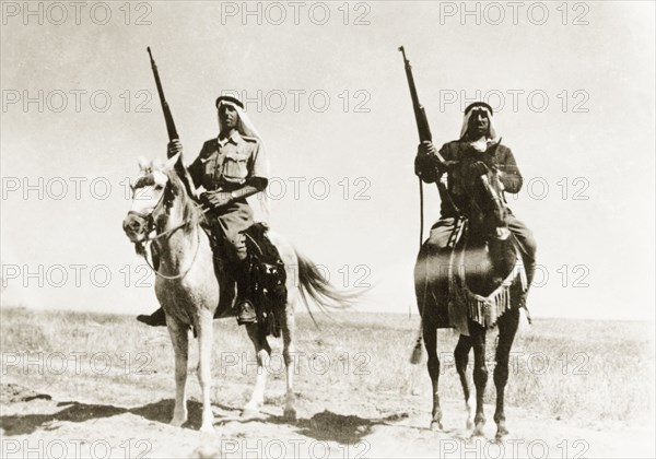 Desert police on patrol. Two mounted Arab police officers patrol the desert with rifles during the period of the Great Uprising (1936-39). British Mandate of Palestine (Middle East), circa 1938., Middle East, Asia.
