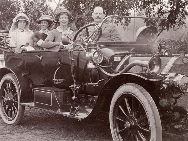 Driving an Itala car, India. Three European women and their male companion take a spin in a convertible Itala car. An original caption identifies the man as 'Pining Peliti, famous for his restaurants in Calcutta and Simla', and suggests this may be Italian restaurateur, Federico Peliti. Probably Calcutta (Kolkata), India, circa 1916. Kolkata, West Bengal, India, Southern Asia, Asia.