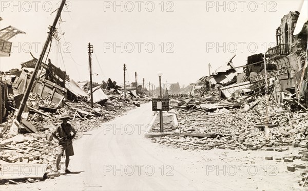 Earthquake damaged street in Quetta. A European man stands on a devastated street in Quetta, reduced to rubble by an earthquake measuring 7.7 on the Richter scale. The earthquake hit Balochistan on 31 May 1935, and is thought to have killed between 30,000 to 60,000 people. Quetta, Balochistan, India (Pakistan), 1935. Quetta, Balochistan, Pakistan, Southern Asia, Asia.