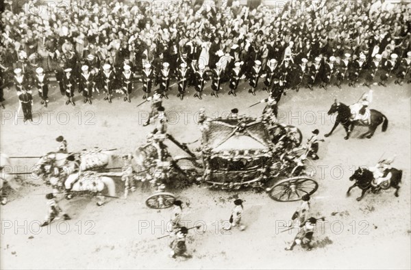 The royal carriage at George VI's coronation procession. Crowds of spectators line Whitehall to watch the coronation procession of King George VI on its way to Westminster Abbey. The King and Queen Elizabeth travel in the Gold State Coach, surrounded by a mounted military escort. London, England, 12 May 1937. London, London, City of, England (United Kingdom), Western Europe, Europe .