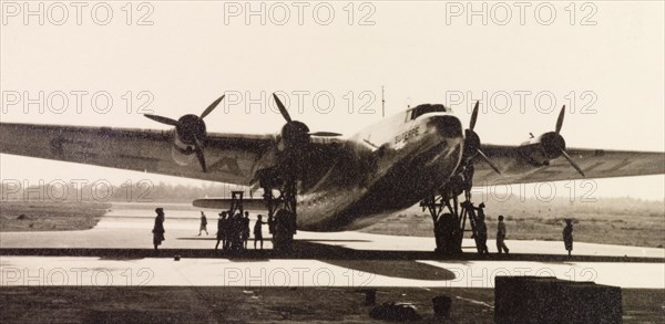 Euterpe' at Dum Dum Airport. Imperial Airways aircraft 'Euterpe' is parked for refuelling on the runway at Dum Dum Airport (now Netaji Subhash Chandra Bose International Airport). Dum Dum, Calcutta (Kolkata), India, December 1938. Kolkata, West Bengal, India, Southern Asia, Asia.