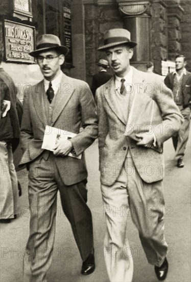 City gents in Sydney. James Murray (left) and a male companion walk purposefully along a city street in Sydney wearing suits and trilby hats. The pair were visiting Australia whilst on leave from colonial service in India. Sydney, Australia, April 1940. Sydney, New South Wales, Australia, Australia, Oceania.