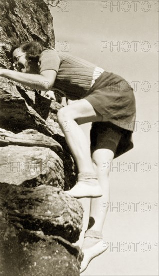 Climbing in Burragorang Valley. A European woman laughs as she struggles to climb a cliff face in Burragorang Valley whilst on holiday in the Blue Mountains. New South Wales, Australia, May 1940., New South Wales, Australia, Australia, Oceania.