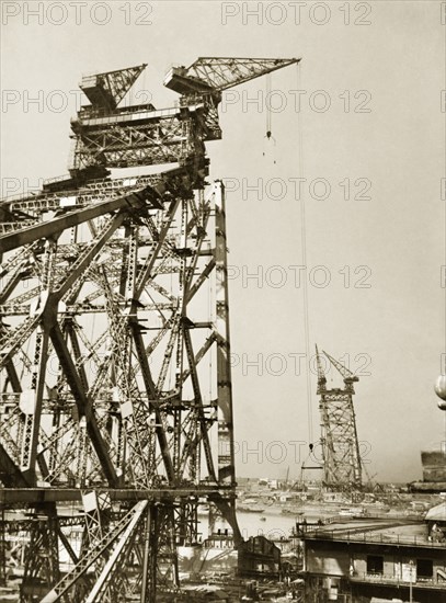 The Howrah Bridge under construction, 1940. The Howrah Bridge under construction across the Hooghly River, linking the cities of Howrah and Calcutta. Construction of the bridge started in 1937 and was completed in 1943. Calcutta (Kolkata), India, November 1940. Kolkata, West Bengal, India, Southern Asia, Asia.