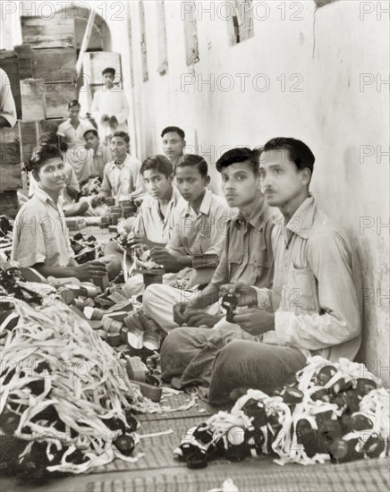 Workers in a goggle factory, Calcutta. Indian factory workers inspect and box up hundreds of pairs of sun and dust goggles to be sent out to British forces in the Middle East. Located on Barrackpore Road in Calcutta, this factory manufactured over a million pairs of goggles during the Second World War. Calcutta (Kolkata), India, circa 1944., West Bengal, India, Southern Asia, Asia.