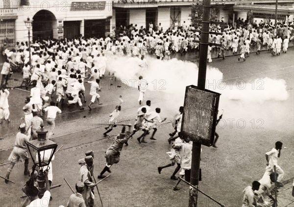 Police disperse riots in Calcutta, 1946. Indian police use lathis (bamboo sticks) and tear gas to disperse rioting crowds of Indian protesters on Old Court House Street. The photographer refers to the event as a "Communist riot", but it could be any one of a number of uprisings that plagued Calcutta in 1946. Two occasions that seem to fit are an attempt by student demonstrators to enter Dalhousie Square on 11 February, or the August riots relating to Direct Action Day. Calcutta (Kolkata), India, 1946. Kolkata, West Bengal, India, Southern Asia, Asia.