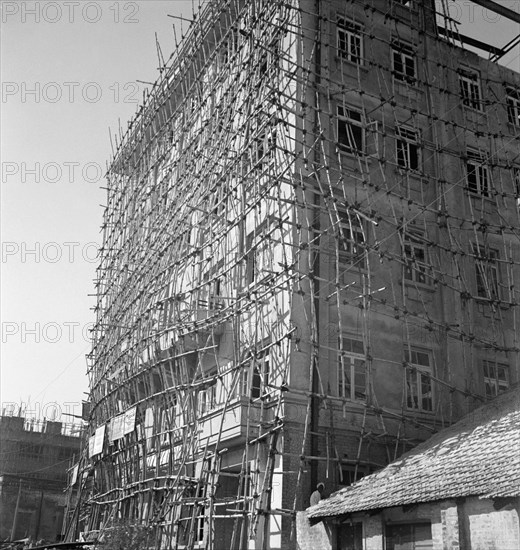 Bamboo scaffolding, Calcutta. A tall building is encased in bamboo scaffolding as it undergoes construction. Calcutta (Kolkata), India, circa 1940. Kolkata, West Bengal, India, Southern Asia, Asia.
