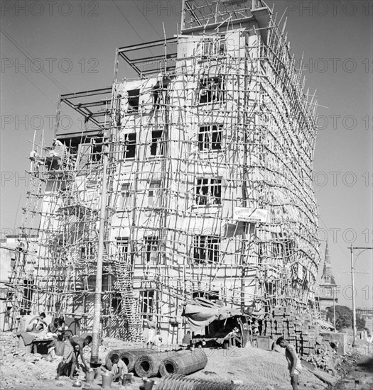 Construction of a six-storey building, Calcutta. A partially completed building is encased with bamboo scaffolding at a construction site in Calcutta. Calcutta (Kolkata), India, circa 1940. Kolkata, West Bengal, India, Southern Asia, Asia.