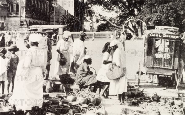 Roadside market, Barbados. Street traders sell pots and jugs at a roadside market stall in Barbados, where a 'Cool Drinks' cart has pulled over to peddle its trade. St Michael, Barbados, circa 1930., St Michael, Barbados, Caribbean, North America .