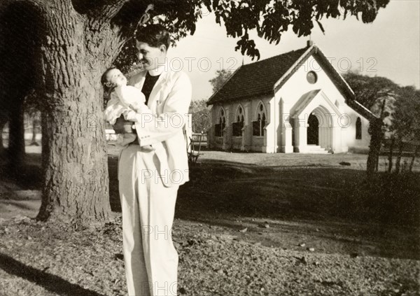 Methodist missionary cradling his daughter. Methodist missionary Reverend Norman Sargant cradles his baby daughter Nell outside Chikmagalur Church. Chikmagalur, Mysore State (Chikkamagaluru, Karnataka), India, February 1937., Karnataka, India, Southern Asia, Asia.