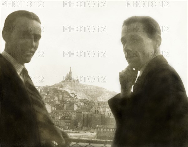 Visiting Marseille. Two British men pose whilst looking over the city of Marseille, where the church of Notre-Dame de la Garde can be seen atop a hill towering above the city. This photograph was taken at a stopover in Marseille during a sea voyage from England to India. Marseille, France, 1931. Marseille, Provence-Alpes-Cote d'Azur, France, Western Europe, Europe .