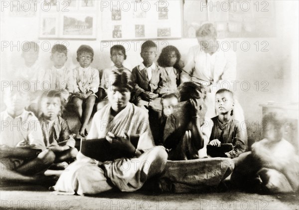 Class of Indian schoolchildren. A mixed gender class of Indian schoolchildren listen and take notes during a lesson at a Methodist mission school. Tumkur, Mysore State (Tumakuru, Karnataka), India, 1932., Karnataka, India, Southern Asia, Asia.