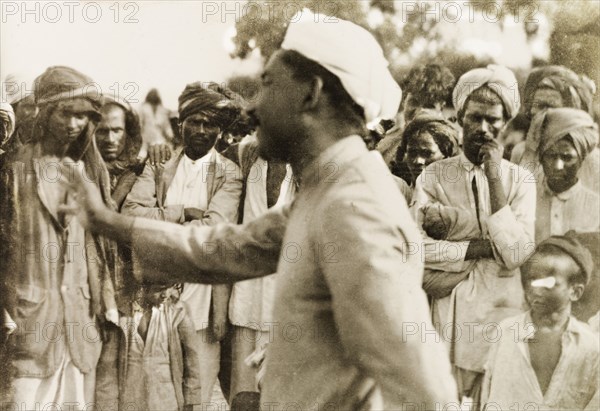 Evangelist preaching to villagers. Methodist evangelist T.B. William preaches to a gathered crowd of Indian villagers. T.B. William was accompanying British missionary Reverend Norman Sargant, who travelled throughout Mysore State preaching to rural Christian communities. Mysore State (Karnataka), India, 1933., Karnataka, India, Southern Asia, Asia.