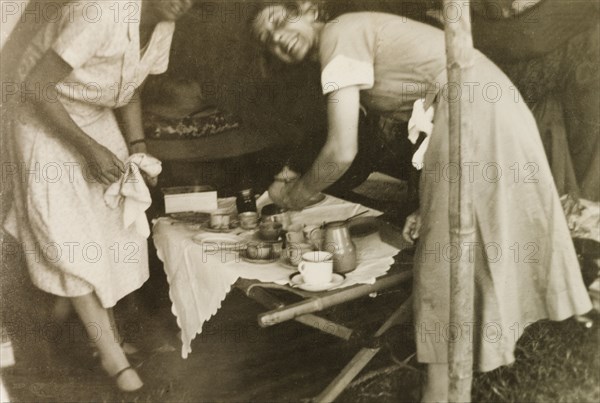 Nurses at a missionary medical camp. Two European nurses prepare drinks in a tent at a Methodist mission medical camp. Mysore State (Karnataka), India, 1934., Karnataka, India, Southern Asia, Asia.