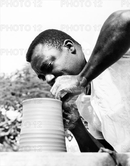 An Antiguan potter. An Antiguan potter skilfully turns a clay pot on a revolving wheel. Antigua, 1965. Antigua and Barbuda, Caribbean, North America .
