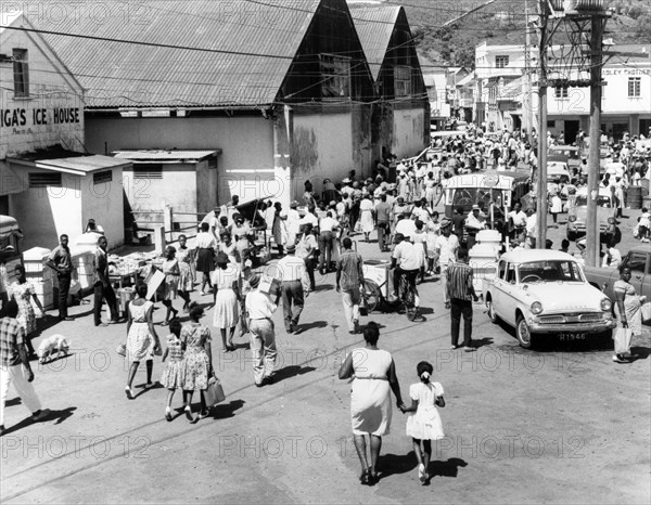 Market day in Kingston, St Vincent. Crowds of people and traffic fill a side street in Kingstown on market day. Kingstown, St Vincent, 1965. Kingstown, St George (St Vincent and the Grenadines), St Vincent and the Grenadines, Caribbean, North America .