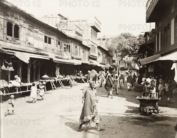 Commercial street in Peshawar. View along a commercial street in Peshawar, where shoppers browse trader's goods under the awnings of open-fronted shops. Peshawar, India (Pakistan), February 1903. Peshawar, North West Frontier Province, Pakistan, Southern Asia, Asia.