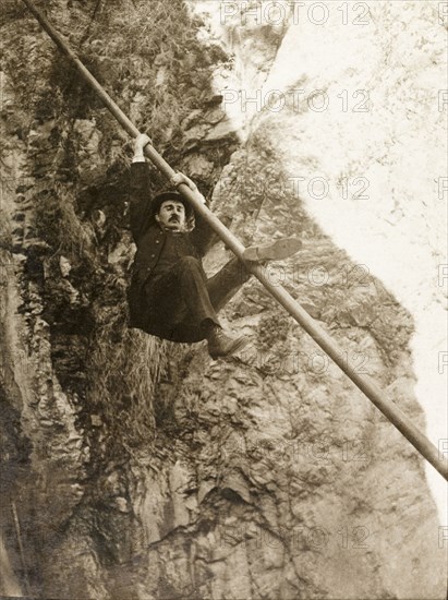 Monkeying around, California. A Frenchman, Mr Fisher, attempts to climb a pipe during an excursion to Rubio Canyon with British traveller Henry Crowe. Pasadena, California, United States of America, March 1902., California, United States of America, North America, North America .