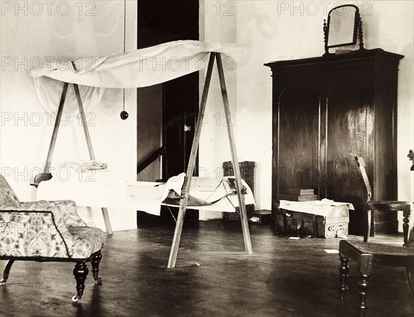 Guest room in colonial house, Colombo. Interior of a guest room in a colonial house in Colombo, equipped with a temporary camp bed and mosquito net. Photograph taken during the stay of traveller Henry Warren Crowe, who was undertaking a world tour from 1902 to 1904. Colombo, Ceylon (Sri Lanka), November 1902. Colombo, West (Sri Lanka), Sri Lanka, Southern Asia, Asia.