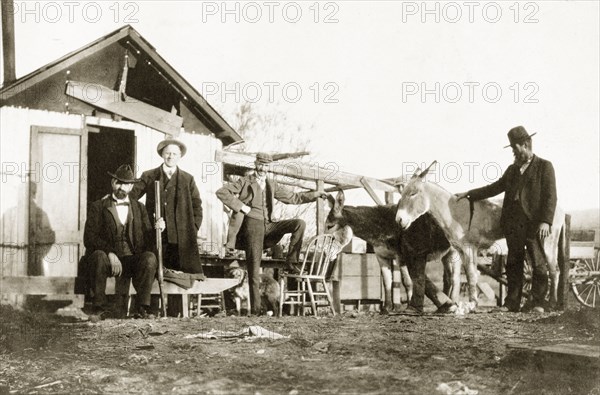 Expedition to Red Cloud gold mine'. Four European men (three who are identified as Dr Allen, Dr Jewell and Mr Spencer) pose by the entrance of a wooden hut at Red Cloud gold mine in the Chuckwalla Mountains. California, United States of America, 1902., California, United States of America, North America, North America .