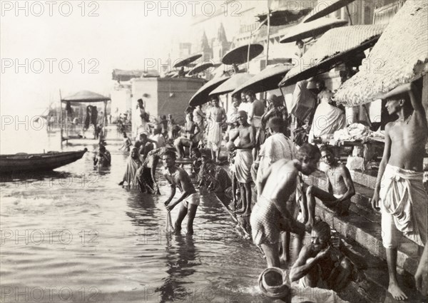 A bathing ghat, Benares. Hindu pilgrims bathe at a ghat (stepped wharf) on the River Ganges at Benares, one of Hinduism's holiest sites. Benares, United Provinces (Varanasi, Uttar Pradesh), India, December 1902. Varanasi, Uttar Pradesh, India, Southern Asia, Asia.
