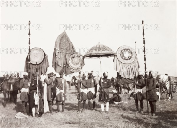 Standard-bearers of Rewah State, 1903. The standard-bearers of Rewah State display a selection of ceremonial umbrellas, banners and staffs at the Coronation Durbar. Delhi, India, circa 1 January 1903. Delhi, Delhi, India, Southern Asia, Asia.