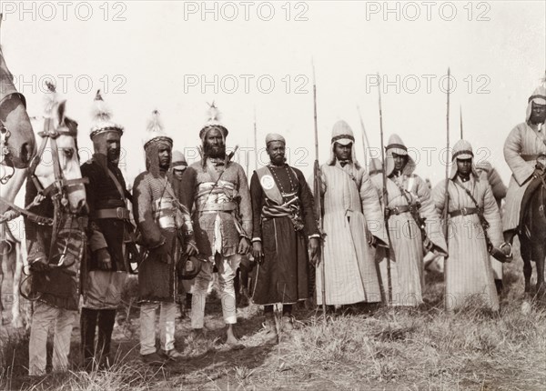 Kishengarh State's mounted infantry at Coronation Durbar, 1903. A regiment of Kishengarh State's mounted infantry at the Coronation Durbar. The lancers wear long, quilted coats with plain, conical helmets, while the infantrymen wear protective tunics, 'dhotis', and feathered helmets. Delhi, India, circa 1 January 1903. Delhi, Delhi, India, Southern Asia, Asia.