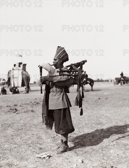 Sikh bearer playing bag pipes. A Sikh bearer plays a bag pipe during celebrations at the Coronation Durbar. Delhi, India, circa 1 January 1903. Delhi, Delhi, India, Southern Asia, Asia.