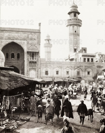Marketplace in Lahore. View across a bustling marketplace to the minarets of the Sunehri Masjid (Golden Mosque), taken from the back of an elephant. Lahore, India (Pakistan), February 1903. Lahore, Punjab, Pakistan, Southern Asia, Asia.