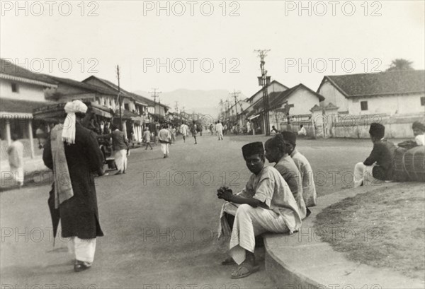 Bazaar Street, Chikmagalur . View of Bazaar Street in Chikmagalur, where crowds wander along the wide, shop-lined street. Chikmagalur, Mysore State (Chikkamagaluru, Karnataka), India, circa 1937., Karnataka, India, Southern Asia, Asia.