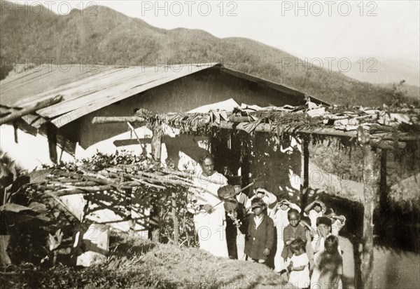 Pandaravalli School, Mysore State. Students of Pandaravalli School participate in a music lesson under a sun shelter outside their school building. The school was founded by Methodist missionaries to educate the children of plantation workers at Pandaravalli coffee estate. Mysore State (Karnataka), India, circa 1937., Karnataka, India, Southern Asia, Asia.