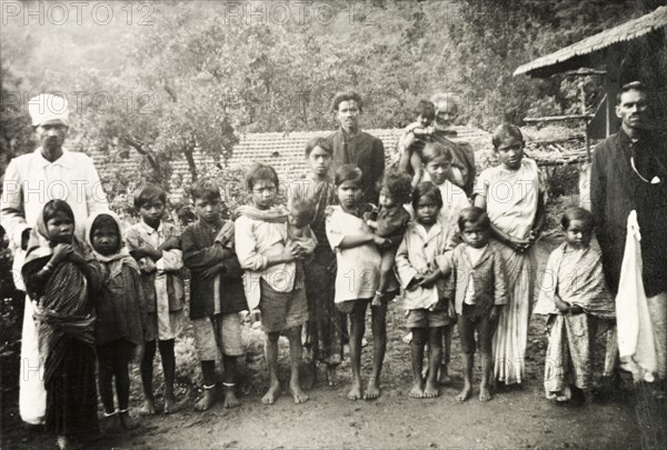 Methodist evangelists at 'Doopadcool Estate'. Two Methodist evangelists, Isaac Maistry (far left) and Monahan Peter (far right), pose for a portrait with a group of Tamil children at 'Doopadcool' coffee estate. Mysore State (Karnataka), India, circa 1937., Karnataka, India, Southern Asia, Asia.