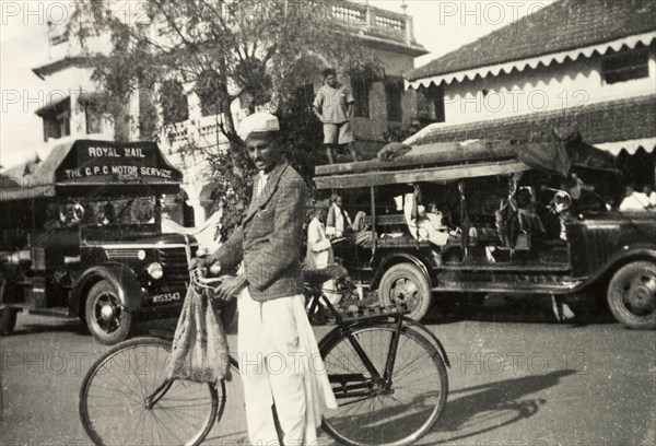 Outside Chikmagalur Post Office. Methodist evangelist Mr S. James poses with his bicycle on the street outside Chikmagalur Post Office. Chikmagalur, Mysore State (Chikkamagaluru, Karnataka), India, circa 1937., Karnataka, India, Southern Asia, Asia.