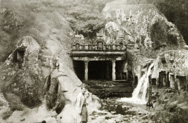 Kalhatti cave temple and waterfall. British colonists Reverend Norman Sargant and Mrs Wilson visit the cave temple at the foot of Kalhatti waterfall. Chikmagalur, Mysore State (Chikkamagaluru, Karnataka), India, circa 1937., Karnataka, India, Southern Asia, Asia.