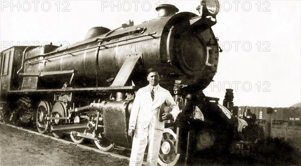 A narrow gauge steam train. Reverend Norman Sargant poses in front of a narrow gauge steam train as he prepares to travel from Mysore to Poona (Pune). Mysore, India, September 1938. Mysore, Karnataka, India, Southern Asia, Asia.