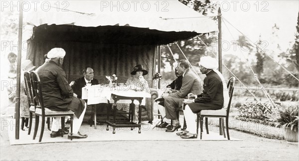 Afternoon tea party at Lal Bagh Palace. Lord Irwin, Viceroy of India, dines with government officials and dignitaries under a 'shamianah' (canopy) in the grounds of Lal Bagh Palace. The group were attending an afternoon tea party held in honour of the viceregal visit to the princely state of Indore. Indore State (Madhya Pradesh), India, 2 August 1928. Indore, Madhya Pradesh, India, Southern Asia, Asia.