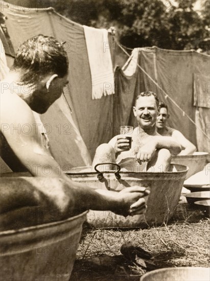 A cold tub for the Calcutta Scottish. Officers of the Calcutta Scottish, an infantry regiment of the British Indian Army, take a cold bath at their outdoor camp after a day on manoeuvres. Midnapore, Bengal (West Bengal), India, 1932. Midnapore, West Bengal, India, Southern Asia, Asia.