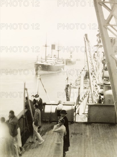 Italian supply ships on the Suez Canal, 1936. Passengers on the deck of S.S. Ranchi look overboard as they pass steamships carrying Italian war supplies on the Suez Canal. The ships were on their way to Abyssinia (Ethiopia) during the Second Italo-Abyssinian War (1935-36). Suez, Egypt, January 1936. Suez, Suez, Egypt, Northern Africa, Africa.