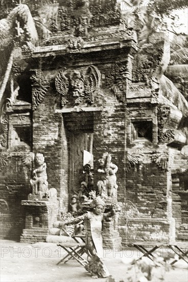 A traditional Balinese dance. A Balinese woman dressed in an elaborate costume performs a traditional dance outside a Hindu temple. Bali, Indonesia, July 1940., Lesser Sunda Islands (including Bali), Indonesia, South East Asia, Asia.