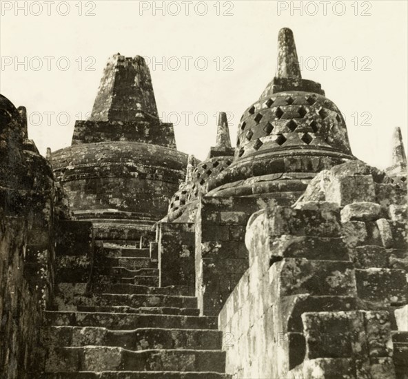 Stupas at the top of Borobudur. View of the domed peak of Borobudur, a ninth century Buddhist monument. The dome is surrounded by bell-shaped stupas, each containing a statue of the Buddha. Java, Indonesia, July 1940., Java, Indonesia, South East Asia, Asia.