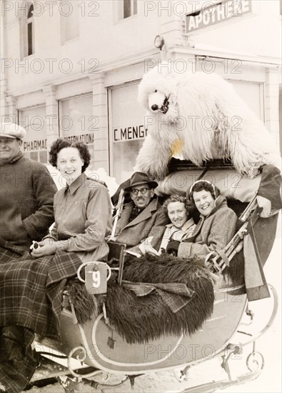 Sleigh ride with a polar bear, Switzerland. A group of British tourists pose with a performer in polar bear costume as they enjoy a sleigh ride at a ski resort. Davos, Switzerland, 1951. Davos, Switzerland, Switzerland, Central Europe, Europe .