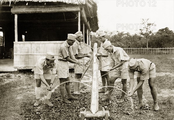 Wash stand at Keningau Health Centre. Trainee health officers at Keningau Health Centre wash their hands at a wash stand fashioned from a length of bamboo. Health officers were trained by British medical officers at the centre to introduce new hygiene and sanitation practices to local villages. Keningau, North Borneo (Sabah, Malaysia), circa 1937. Keningau, Sabah (North Borneo), Malaysia, South East Asia, Asia.