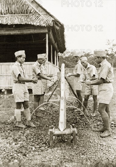 Wash stand at Keningau Health Centre. Trainee health officers at Keningau Health Centre wash their hands at a wash stand fashioned from a length of bamboo. Health officers were trained by British medical officers at the centre to introduce new hygiene and sanitation practices to local villages. Keningau, North Borneo (Sabah, Malaysia), circa 1937. Keningau, Sabah (North Borneo), Malaysia, South East Asia, Asia.