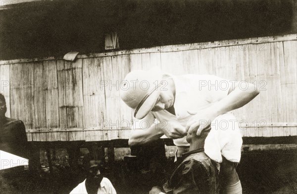 Dental treatment at Keningau Health Centre. A woman receives dental treatment from a trainee at Keningau Health Centre. Health officers were trained by British medical officers at the centre to introduce new hygiene and sanitation practices to local villages. Keningau, North Borneo (Sabah, Malaysia), circa 1937. Keningau, Sabah (North Borneo), Malaysia, South East Asia, Asia.